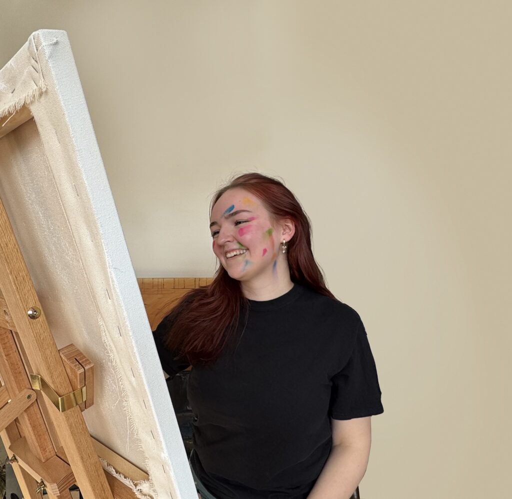 Lillian Acheson pictured painting and smiling.